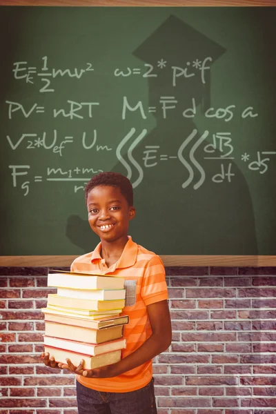 Retrato de niño lindo llevando libros en la biblioteca — Foto de Stock