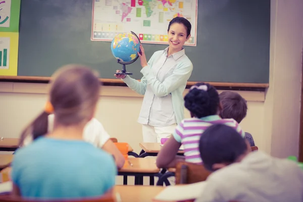 Leerlingen luisteren naar hun leraar houden van globe — Stockfoto