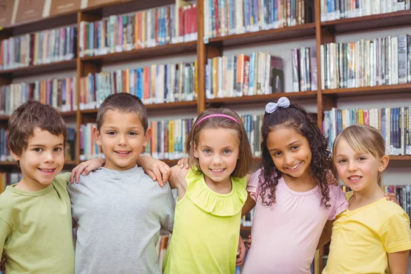 Pupils smiling at camera in library — Stock Photo, Image