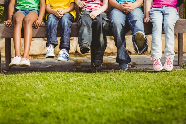 Classmates sitting on bench on campus — Stock Photo, Image