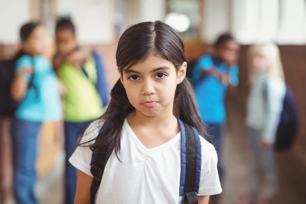 Aluno triste sendo intimidado por colegas de classe no corredor — Fotografia de Stock