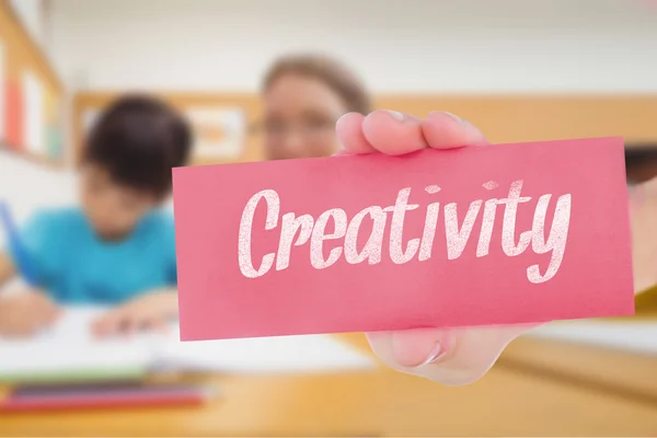 Creativity against pretty teacher helping pupil in classroom — Stock Photo, Image