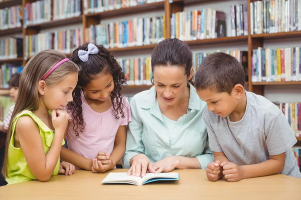 Alumnos y profesores leyendo libro en biblioteca — Foto de Stock