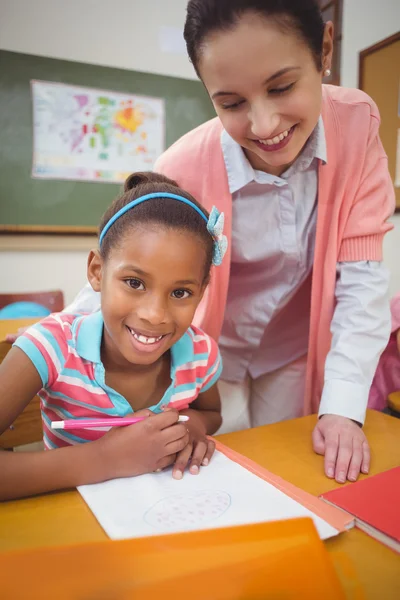 Pupil and teacher at desk in classroom — Stock Photo, Image