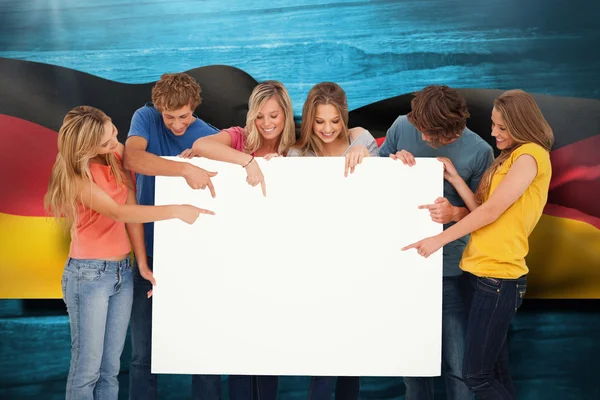 Group holding a blank sheet and pointing to — Stock Photo, Image