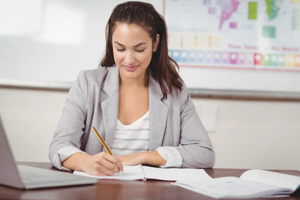 Lehrer korrigiert am Schreibtisch — Stockfoto