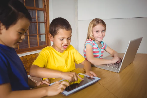 Cute pupilles en classe à l'aide d'un ordinateur portable et tablette — Photo