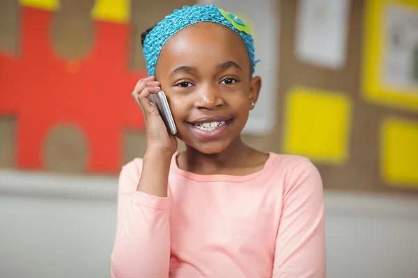 Netter Schüler telefoniert mit Smartphone im Klassenzimmer — Stockfoto