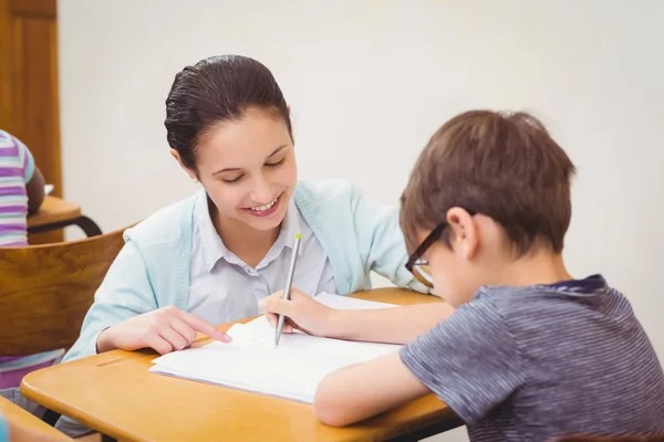 Leraar een kleine jongen helpen tijdens de les — Stockfoto