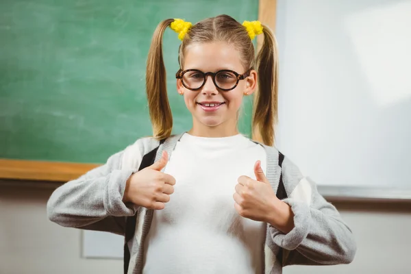 Schattig leerling doen duimen omhoog voor schoolbord — Stockfoto