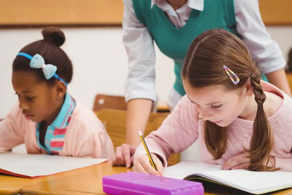 Enseignant aidant petite fille pendant la classe — Photo