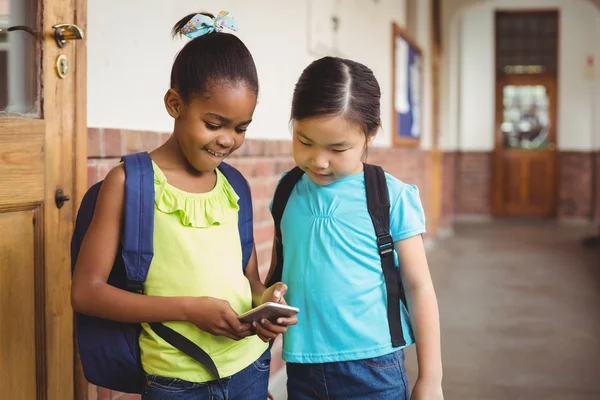 Mignons élèves regardant smartphone — Photo