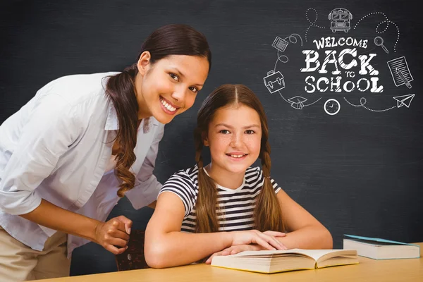 Female teacher and little girl in library — Stock Photo, Image