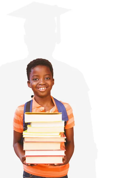 Menino bonito carregando livros na biblioteca — Fotografia de Stock