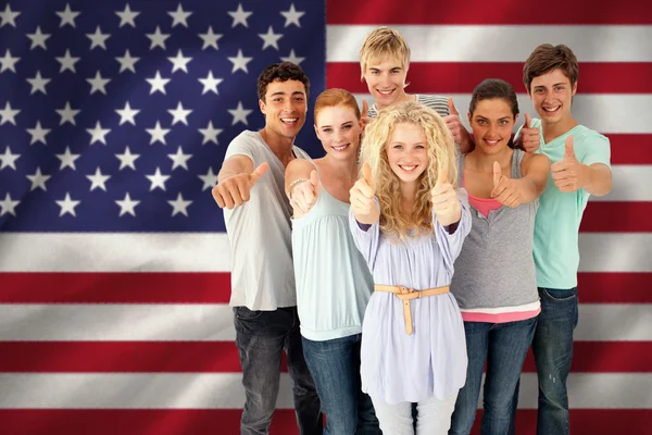 Imagen compuesta de un grupo de adolescentes de pie frente a la c — Foto de Stock