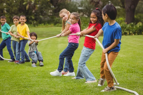 Alumnos jugando tirón de la guerra en la hierba — Foto de Stock