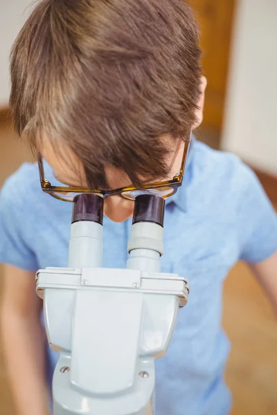 Pupil looking through microscope in class — Stock Photo, Image