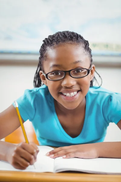 Lächelnde Schülerin am Schreibtisch — Stockfoto