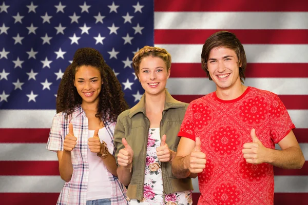 College students gesturing thumbs up in library Stock Picture