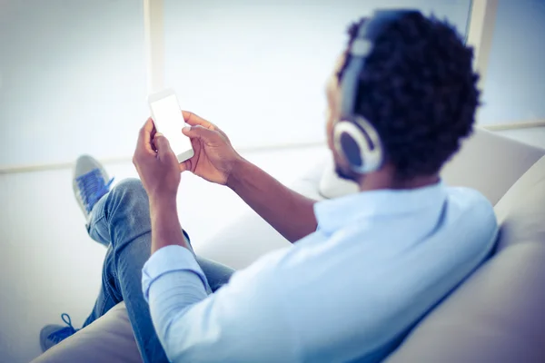 Man met smartphone terwijl u luistert naar muziek — Stockfoto