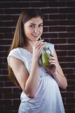 woman sipping on green juice clipart