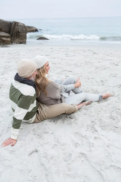 Söta paret sitter i sanden — Stockfoto