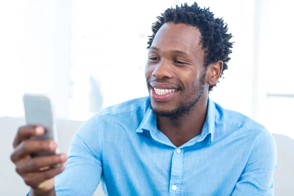 Homem feliz olhando para o telefone móvel — Fotografia de Stock