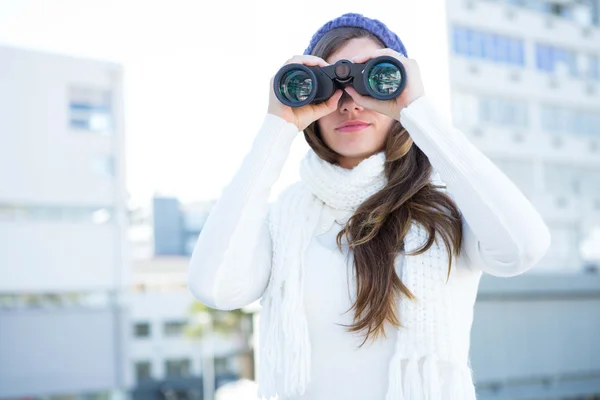 Cold brunette in warm clothes using binoculars — Stock Photo, Image