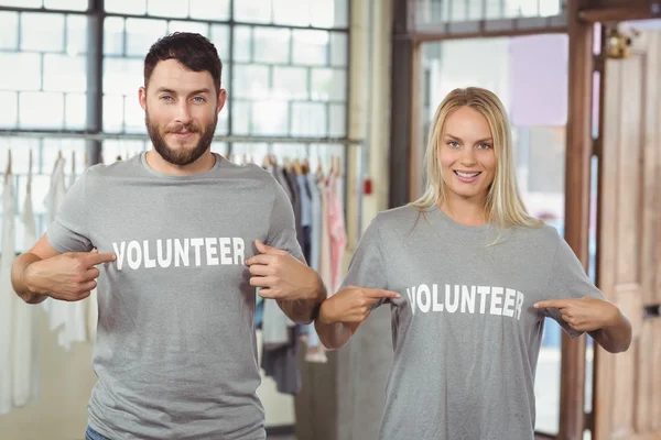 Erkek ve kadın gönüllü metin t-shirt üzerinde gösterilen — Stok fotoğraf