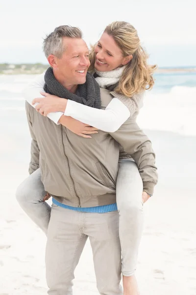 Lächelnder Mann gibt Frau Huckepack zurück — Stockfoto