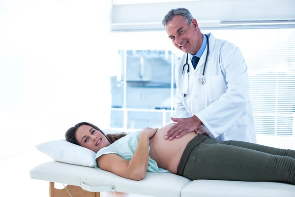 Мужской врач осматривает беременную женщину — стоковое фото