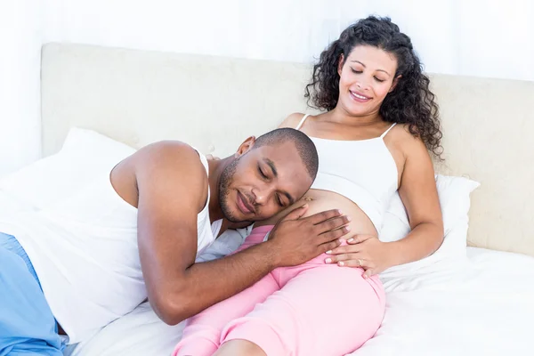 Uomo ascoltando pancia di moglie incinta — Foto Stock