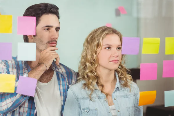 Colleagues reading sticky notes — Stock Photo, Image
