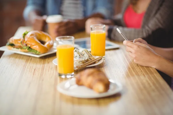 Vrouw met behulp van de telefoon tijdens het ontbijt — Stockfoto