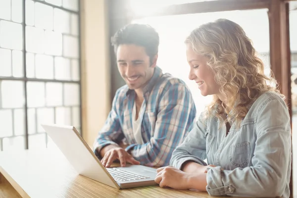 Colleagues looking at laptop in creative office — Stock Photo, Image