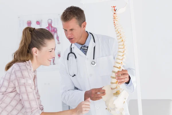 Medico che spiega la colonna vertebrale anatomica al paziente — Foto Stock