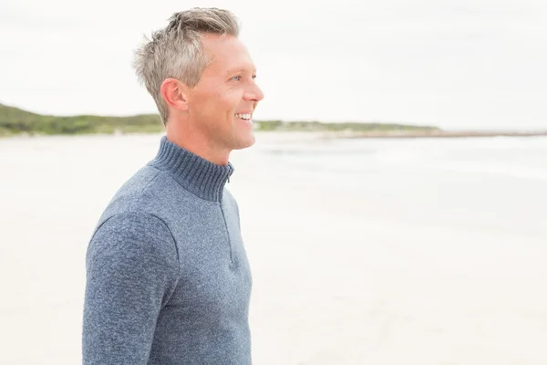 Uomo sorridente in piedi vicino al mare — Foto Stock