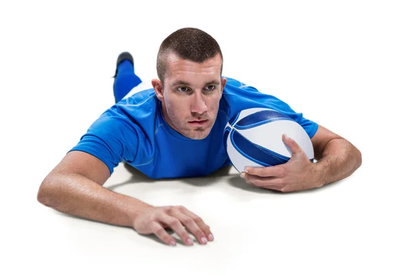 Jogador de rugby deitado com bola — Fotografia de Stock