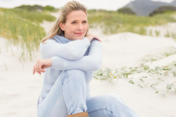 砂の上に座っている笑顔の女性 — ストック写真