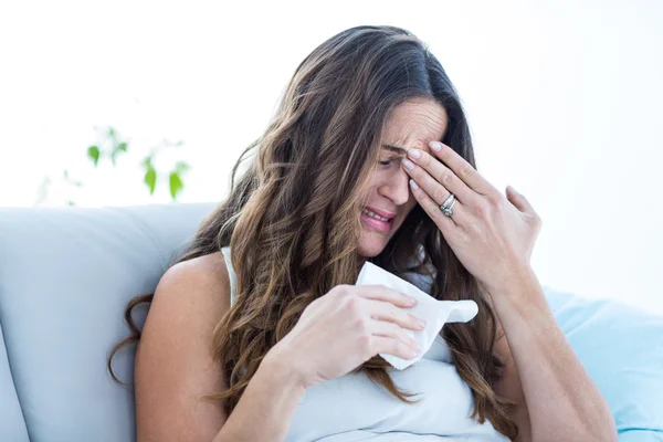 Mulher doente chorando no sofá — Fotografia de Stock