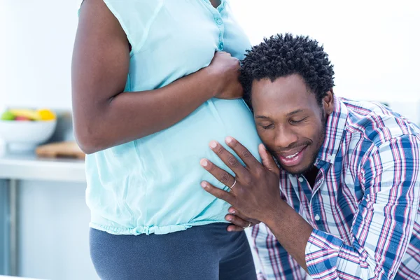 Man lyssnar på gravida hustru mage — Stockfoto