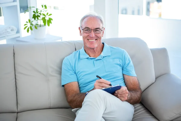 Senior en lunettes assis sur le canapé — Photo