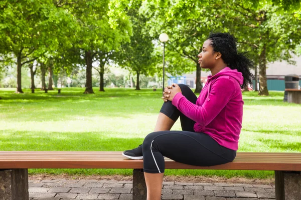 Fit woman sitting on bench — Stock Photo, Image