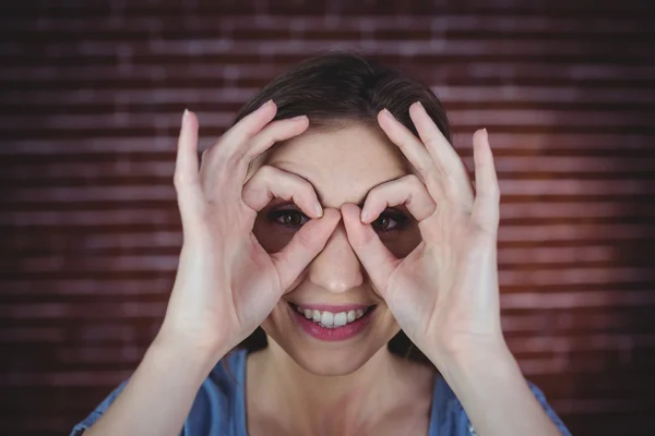 Vrouw bedrijf handen als verrekijkers — Stockfoto