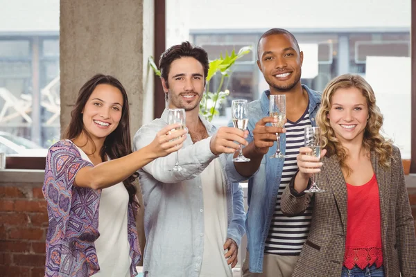 Kollegen stoßen im Büro mit Champagner an — Stockfoto