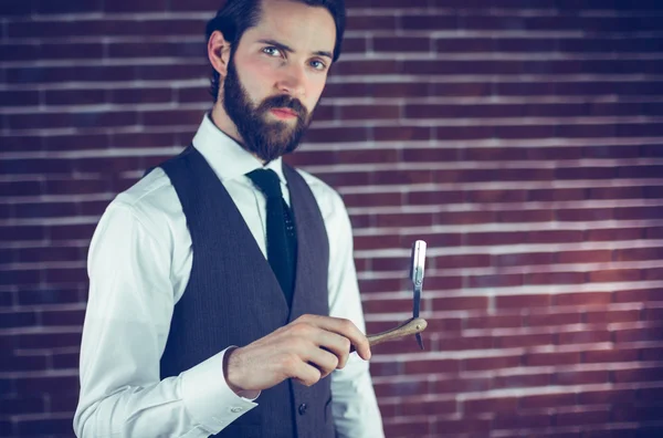 Hombre serio sosteniendo la máquina de afeitar — Foto de Stock