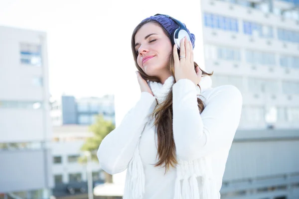Bruna fredda in vestiti caldi ascoltare musica — Foto Stock