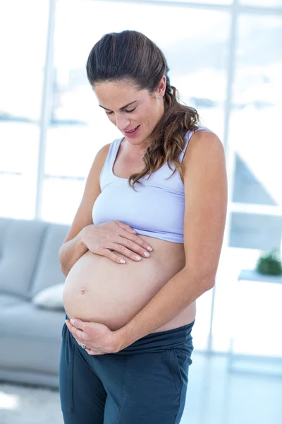 Mulher grávida olhando para a barriga — Fotografia de Stock