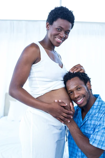 Luisteren naar de buik van zwangere vrouw man — Stockfoto