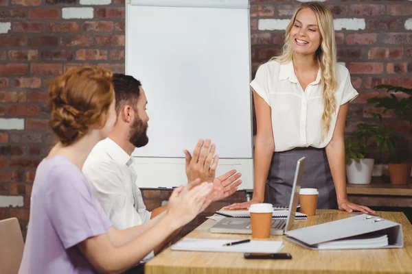 Colleagues applauding businesswoman in office — Stock Photo, Image